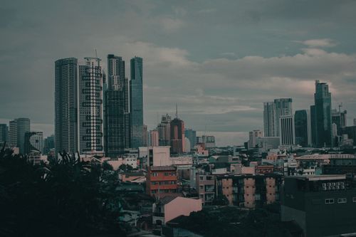 Free Aerial view of a city skyline with skyscrapers under a cloudy sky, conveying a dramatic urban feel. Stock Photo