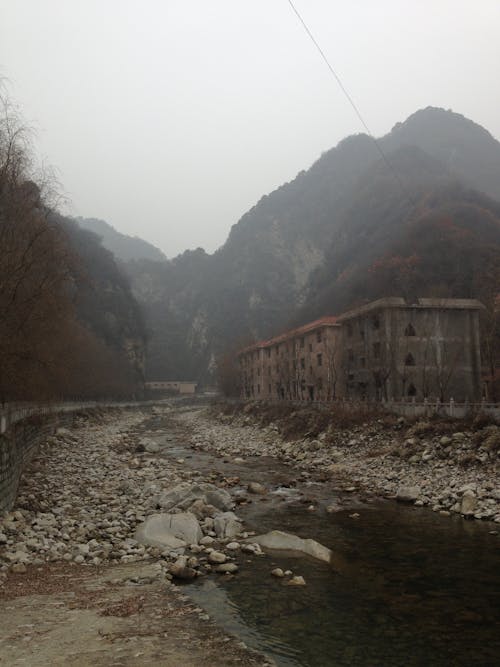 Abandoned Building by a River in Mountains 