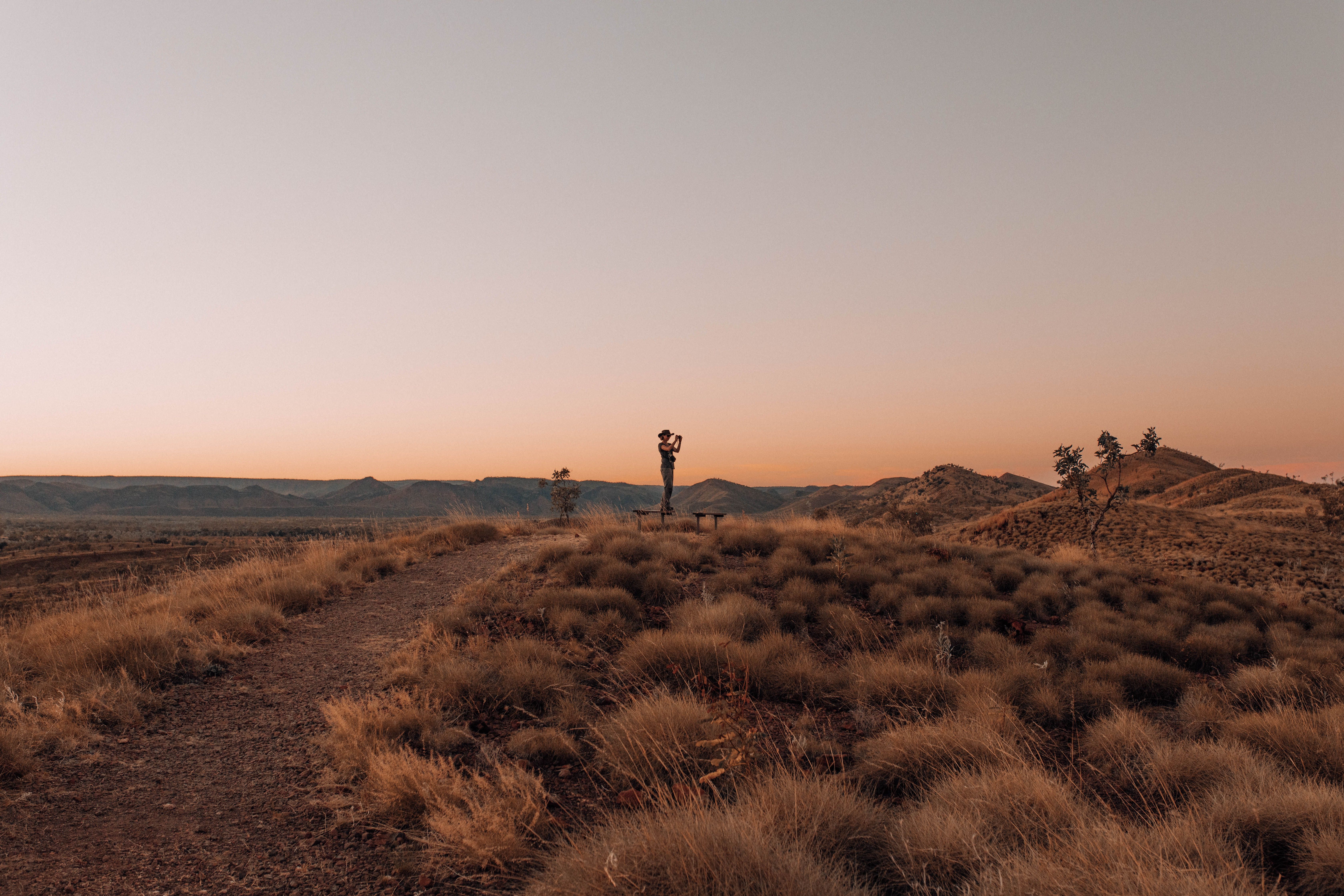 Female Tourist Photographing Arid Landscape at Dusk · Free Stock Photo