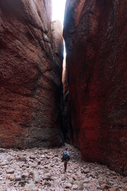Free A lone hiker navigates a narrow canyon with towering rock formations. Stock Photo