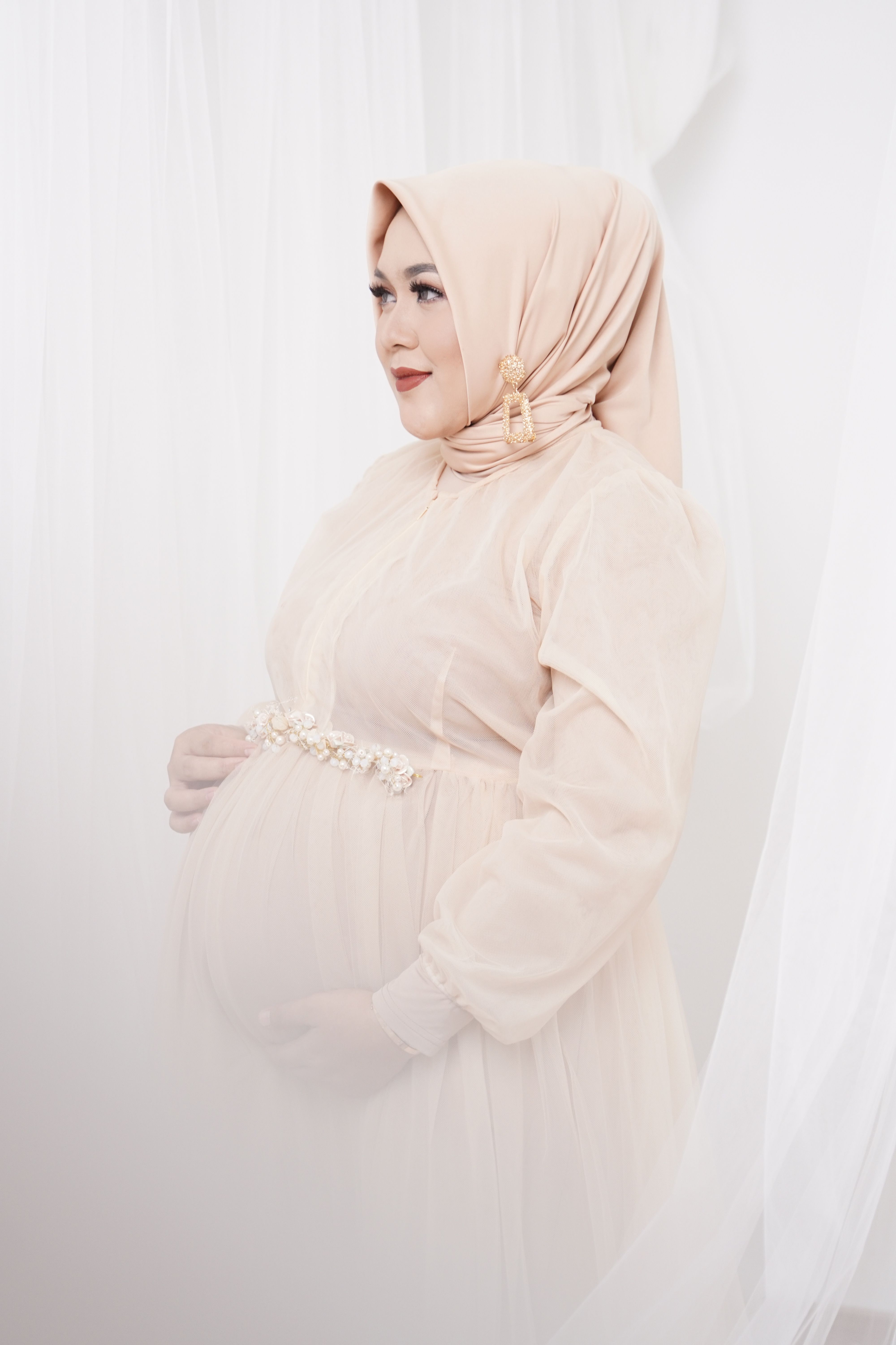 Beautiful maternity portrait of a Muslim woman in a soft, elegant setting. - Fotografer Sidoarjo