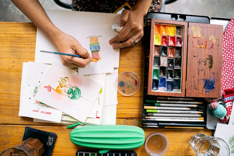 A Person Painting Christmas Postcards