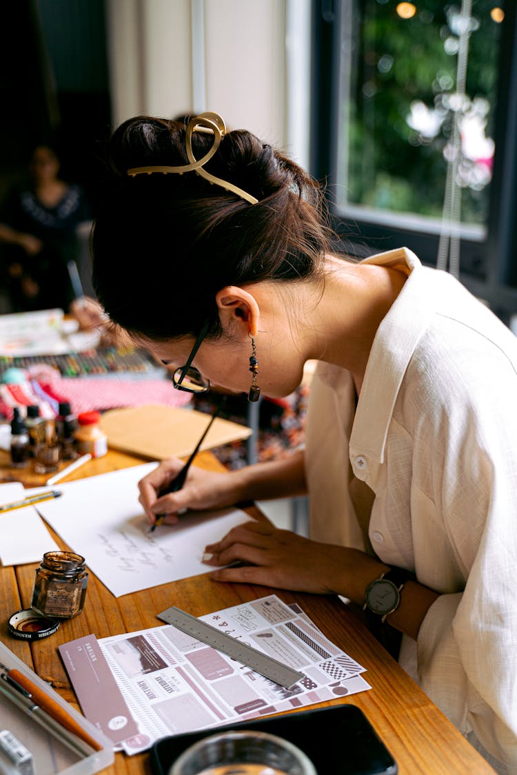 A Calligrapher Writing On Paper