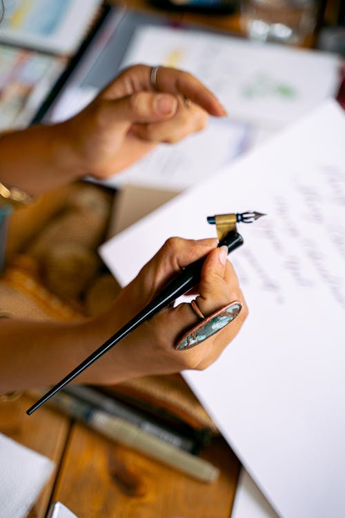 Free Person Holding Black Pen Writing on White Paper Stock Photo