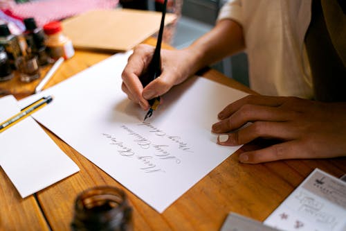Free A Calligrapher Writing on a Paper Stock Photo