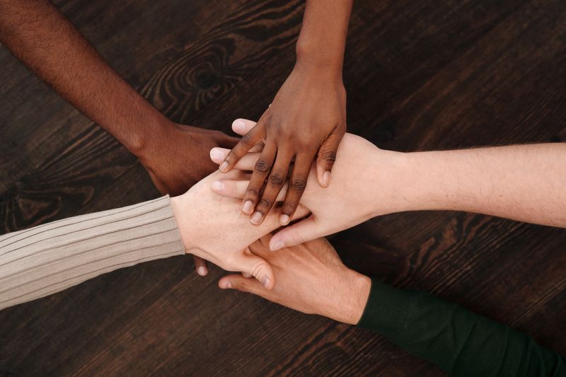 Diverse hands joining together on a wooden surface