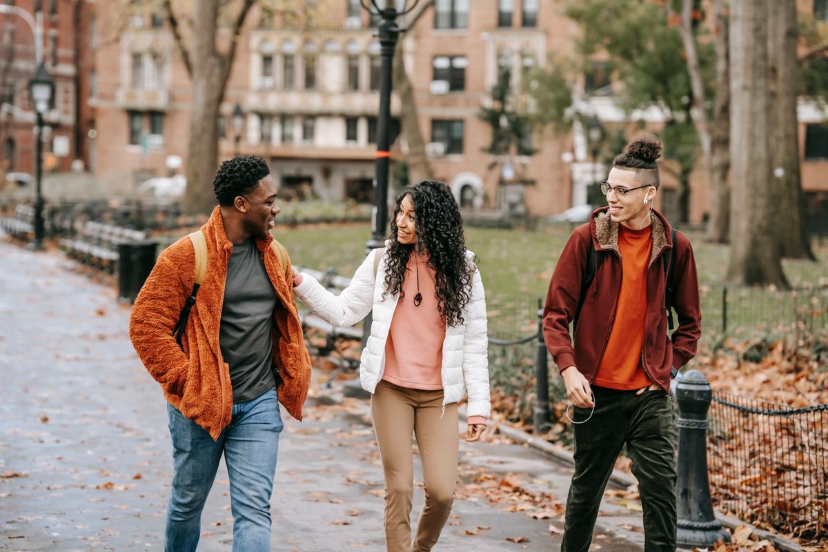 Friends walking and talking together in an autumn park