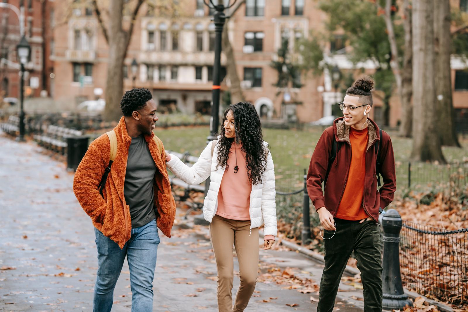 Friends smiling and walking together in a leafy park