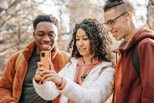 Free Smiling diverse friends making selfie on smartphone Stock Photo