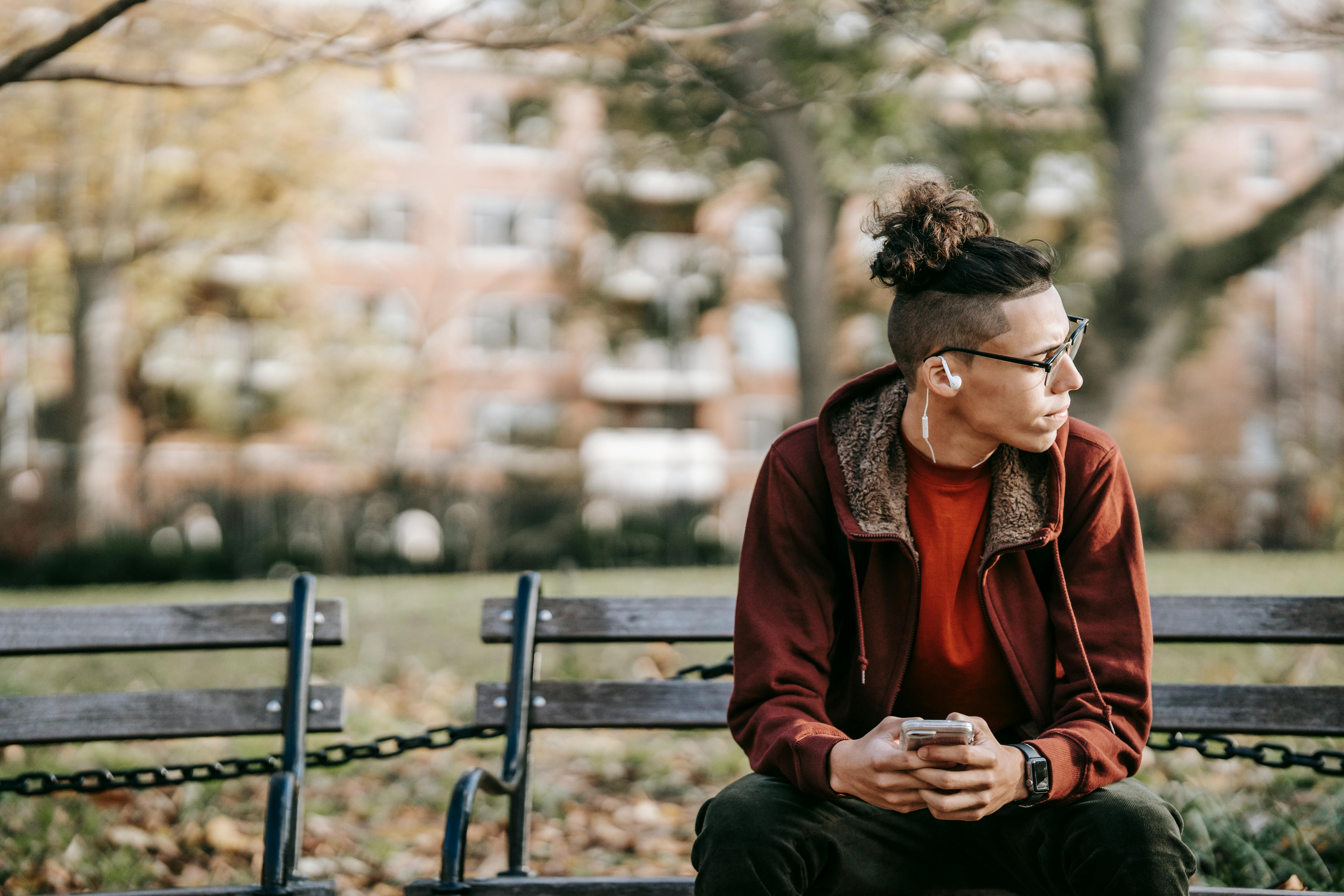 thoughtful man with gadgets in fall park