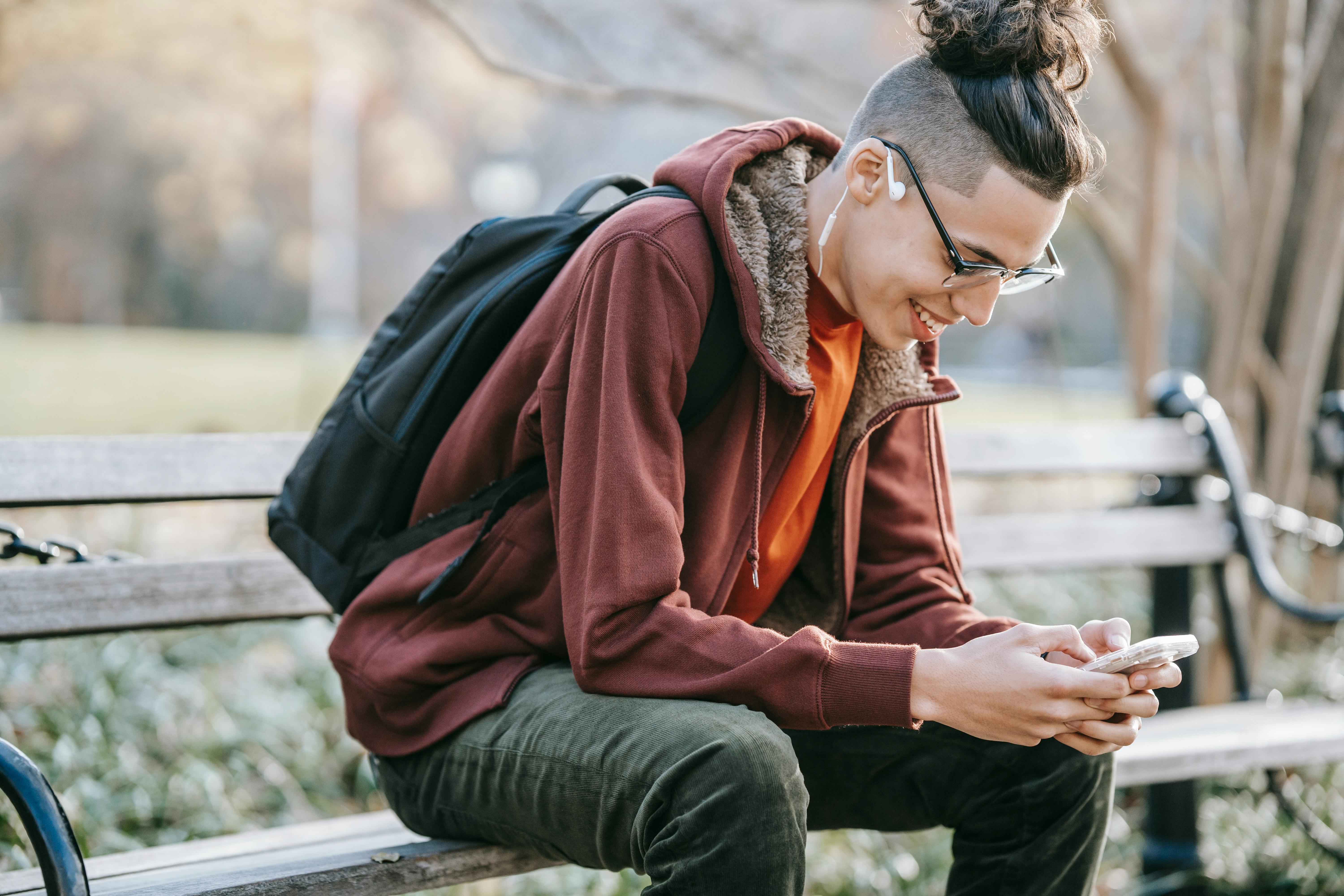 cheerful man with smartphone in park