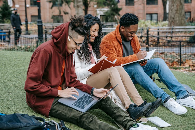 Cheerful Diverse Classmates Studying In Park