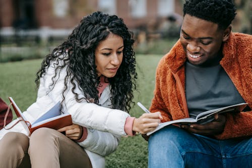 Free Cheerful multiethnic students studying together in campus park Stock Photo