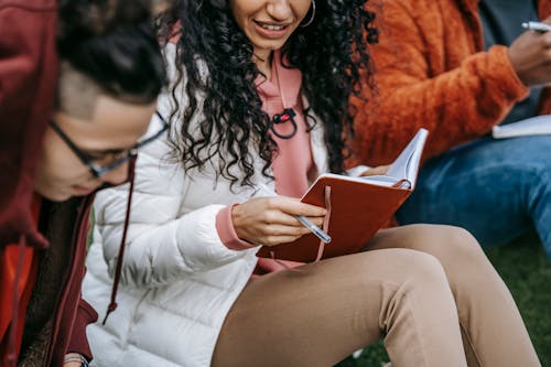 Crop multiethnic students doing homework together