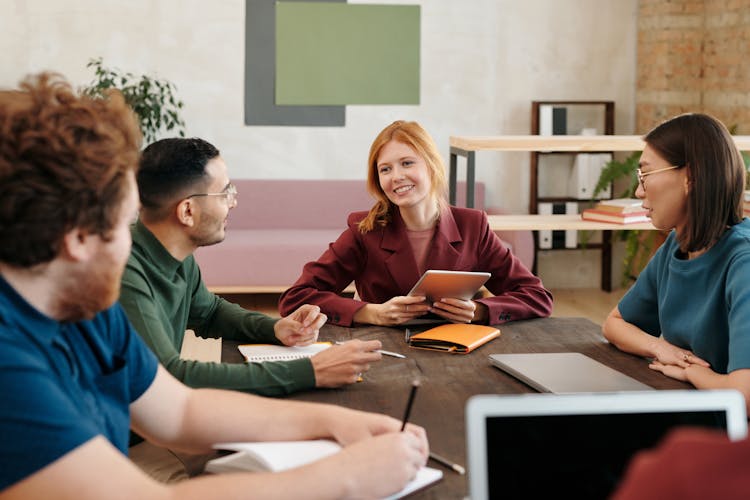 Group Of Students Talking At Table