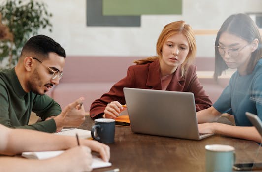 A diverse group of adults engaged in a productive team meeting in a modern office setting.