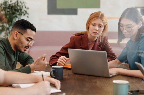 Free A diverse group of adults engaged in a productive team meeting in a modern office setting. Stock Photo