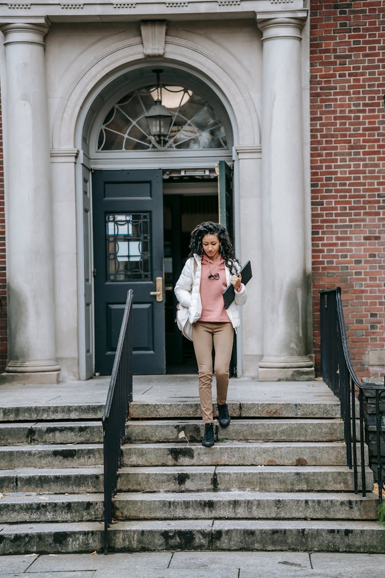 Young Woman With Laptop Near Entrance Of University