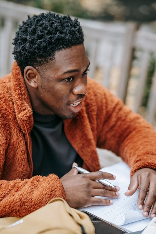 Homme En Veste Orange Tenant Un Smartphone Blanc