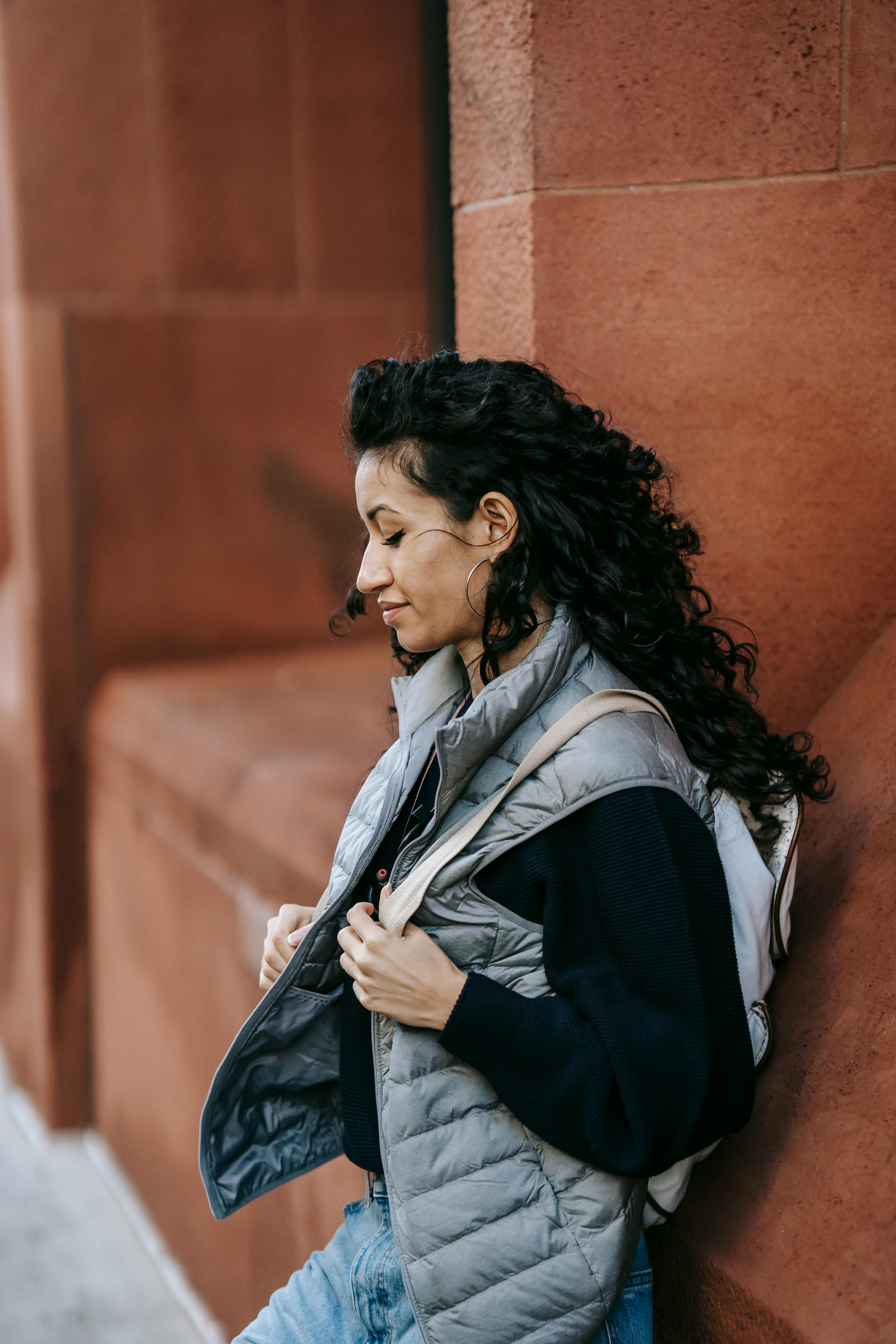 young ethnic lady resting on street after studies