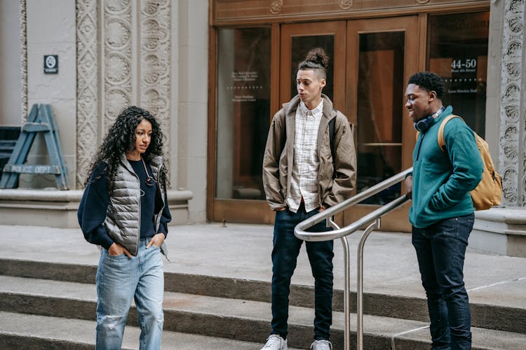 Rebellious Multiracial Male Teens Mocking At Ethnic Female On Street