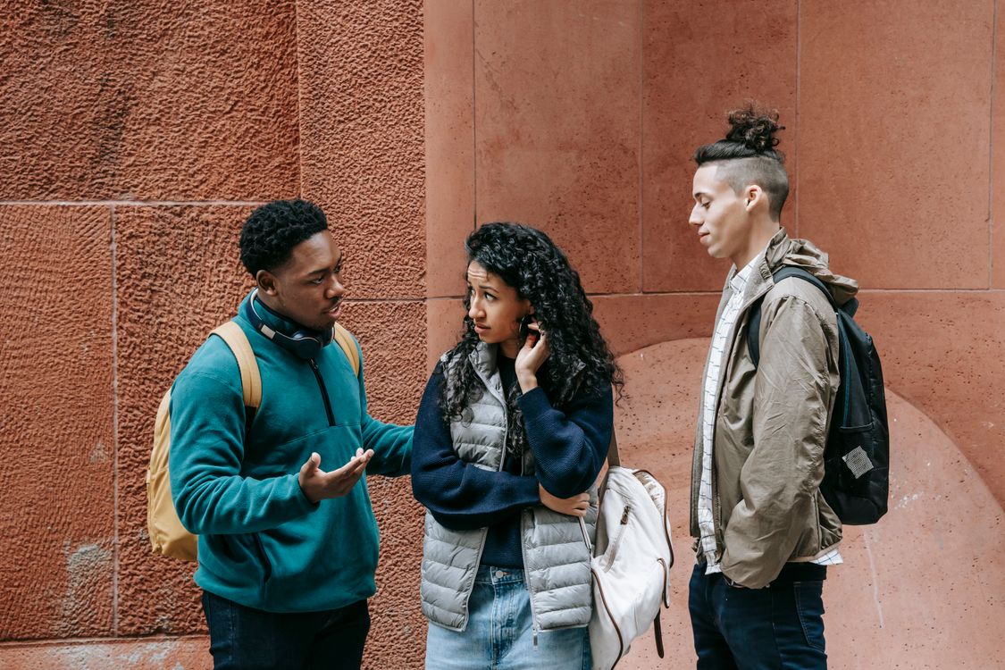Diverse teens chatting on street after studies