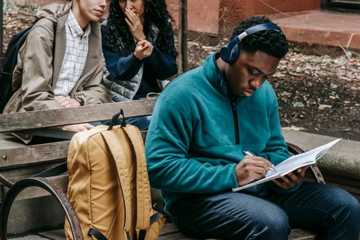 Crop students spreading gossip behind friend