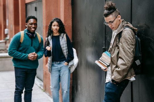 Multiethnic friends annoying classmate in yard