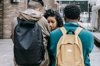 Multiracial young men bullying young woman on street