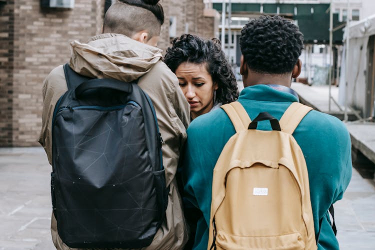 Multiracial Young Men Bullying Young Woman On Street