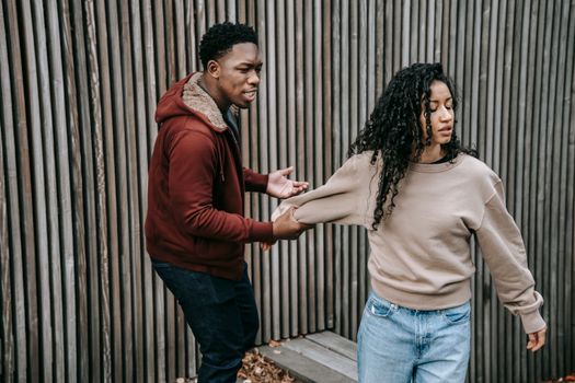 Aggressive black man grabbing offended ethnic woman