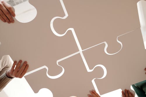 Free Close Up Photo of People Holding Puzzle Pieces Stock Photo