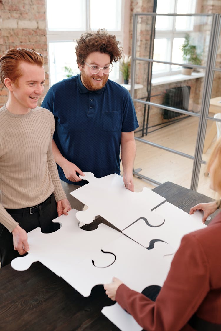 Men Holding Puzzle Pieces