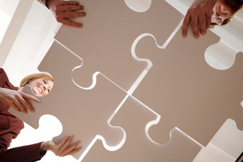 People Holding Gray Puzzle Pieces