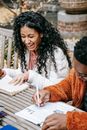 Multiracial students studying with book and papers in park
