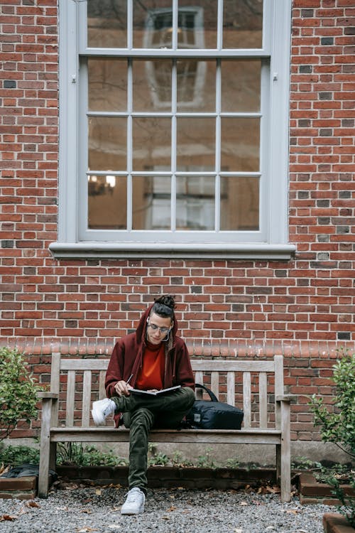 Free Thoughtful guy with notepad in street on bench Stock Photo