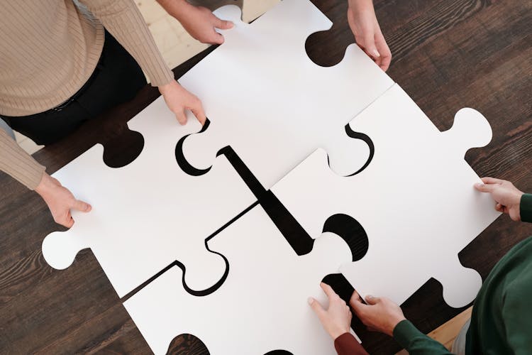 Close Up Photo Of People Holding Puzzle Pieces