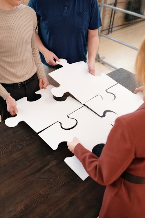 People Holding White Puzzle Pieces