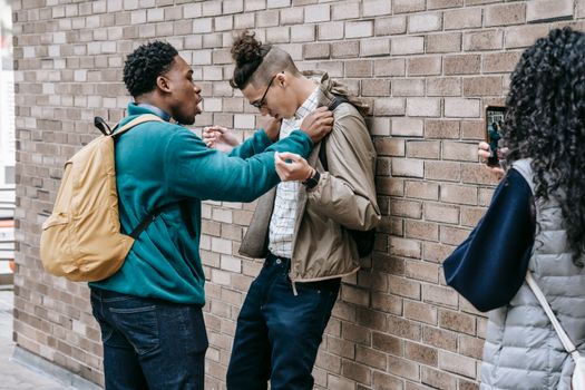 Multiethnic students having conflict on street