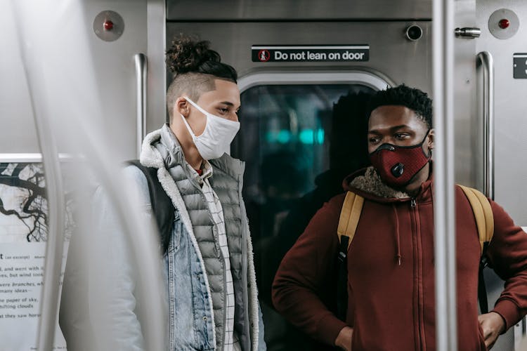 Multiracial Friends In Masks Standing In Subway Train