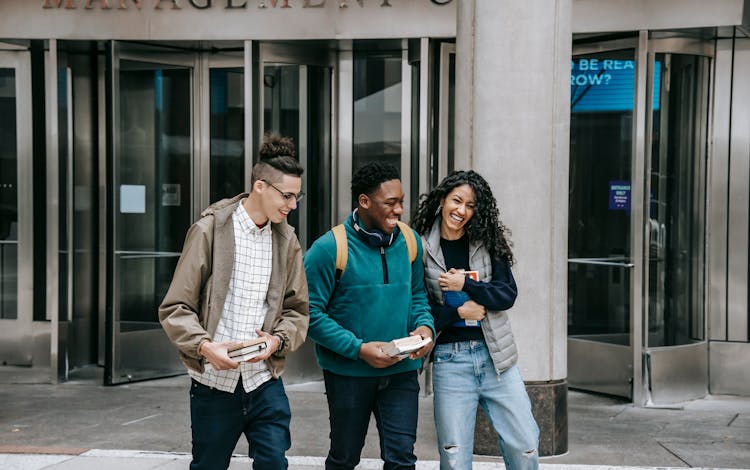 Happy Best Multiracial Friends Laughing On Street Against Building