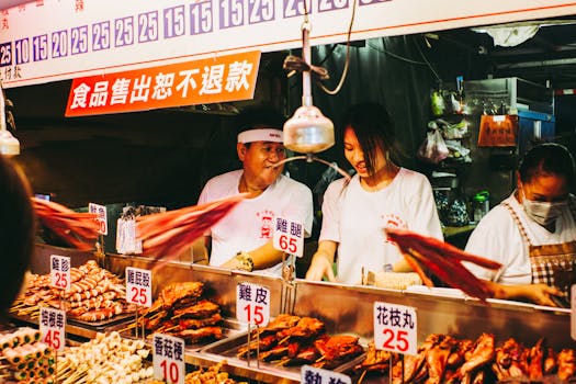 Vibrant scene at a bustling Taiwanese night market food stall with vendors.
