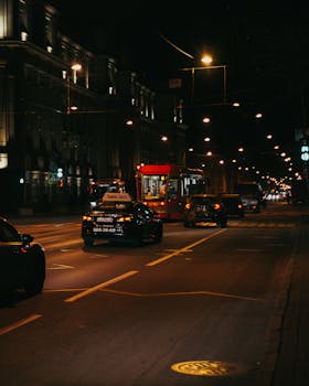 Illuminated urban street in Saint Petersburg with traffic, showcasing vibrant nightlife.