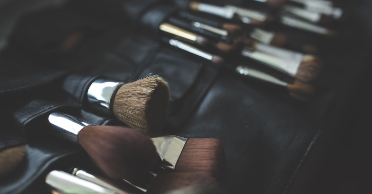 A stylish arrangement of makeup brushes set against a dark, elegant background.