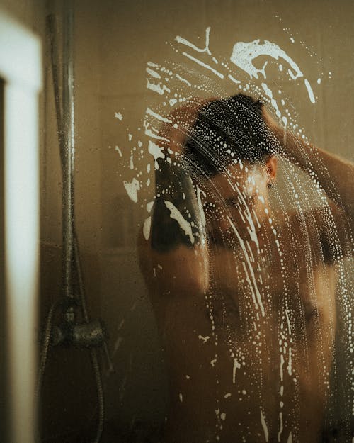 A Man Standing Under the Shower