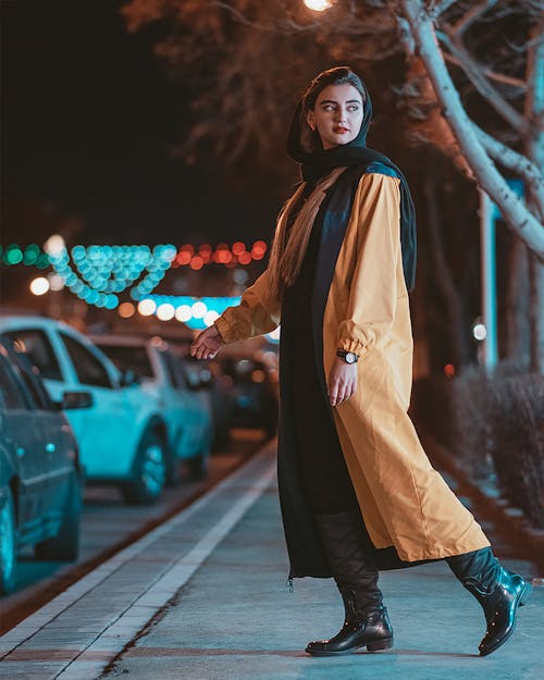 Beautiful Woman in Brown Coat Standing on the Sidewalk while Looking Afar