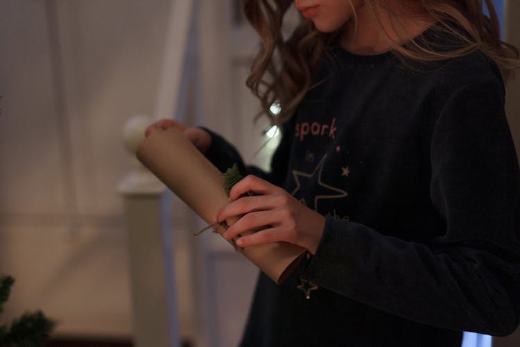 Woman In Black Sweater Holding A Brown Letter