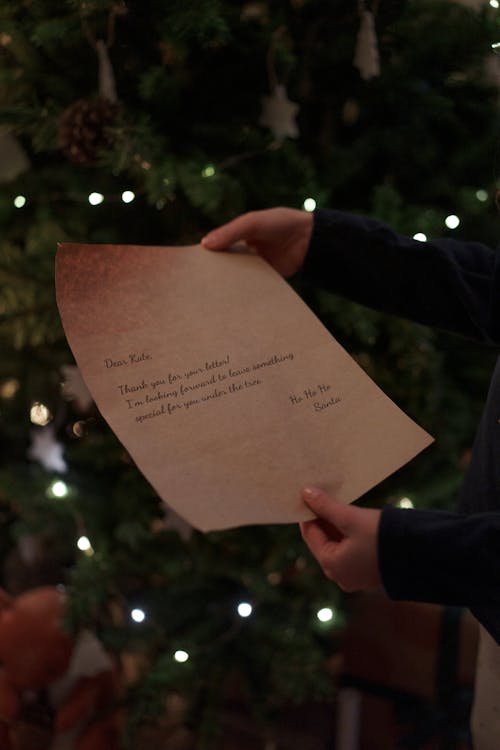 Person Holding Brown Paper With Handwritten Letters