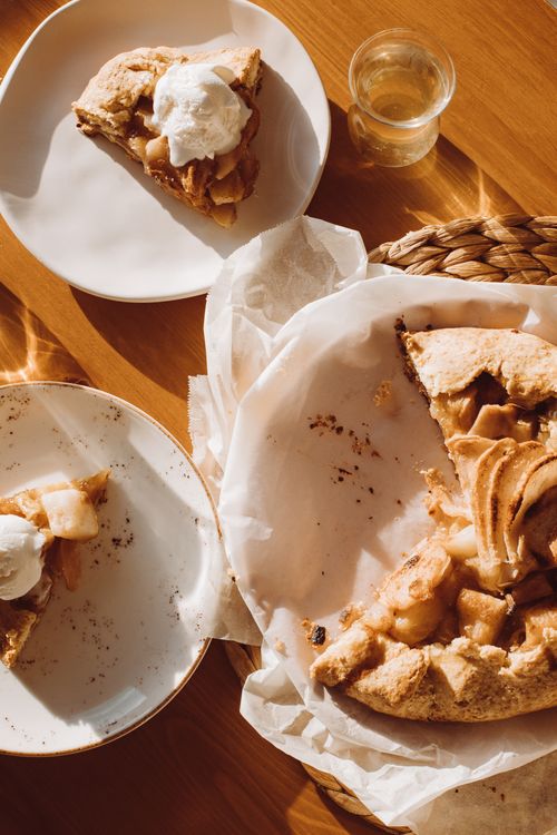 Free Overhead shot of homemade apple pie slices with ice cream, capturing a warm, rustic food presentation. Stock Photo