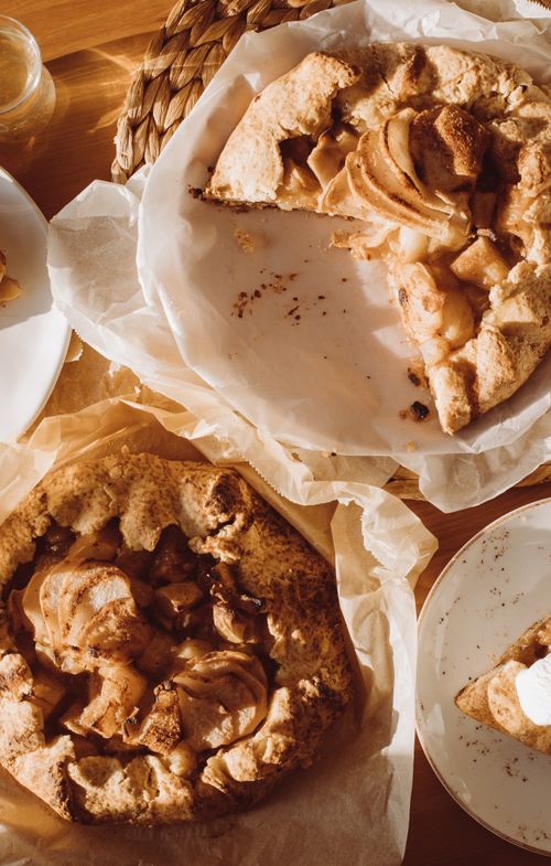Free Top view of rustic homemade apple galettes on parchment paper, perfect for a cozy dessert. Stock Photo